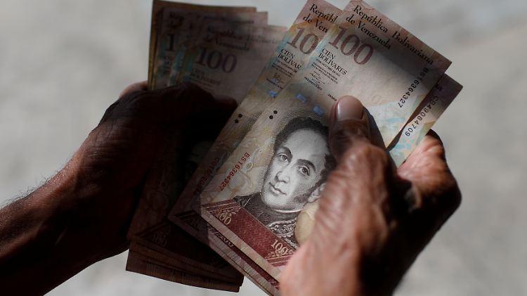 Eine Mann in Venezuela zählt sein Geld. 