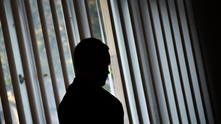 Die Silhouette eines der vier Angeklagten vor einem Fenster im Gerichtssaal.