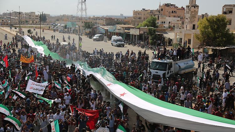 Nach dem türkisch-russischen Abkommen demonstrieren in Idlib Tausende mit einer Oppositionsflagge für den Sturz des syrischen Präsidenten.