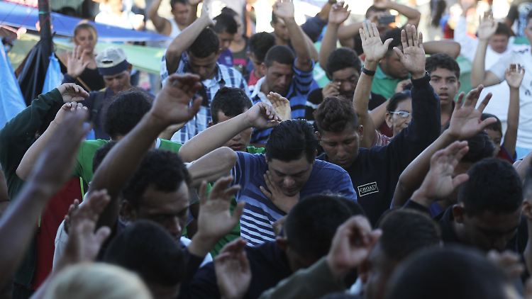 Migranten aus Mittelamerika beten auf dem Hauptplatz der Stadt Huixtla.
