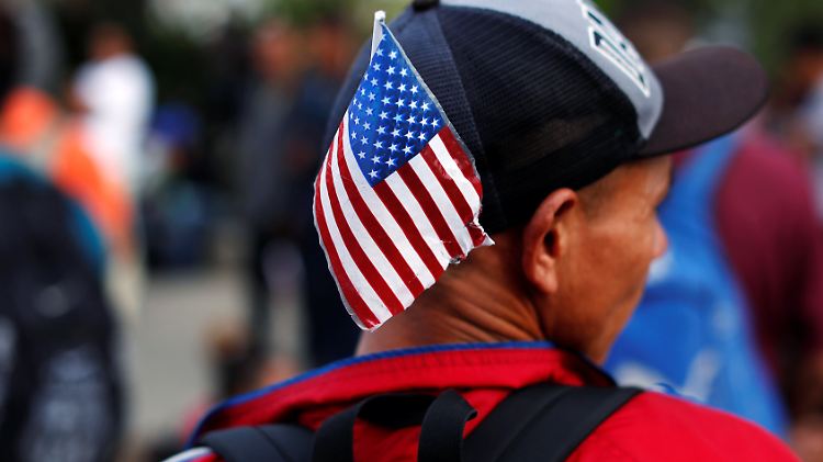 Einer der Migranten trägt an seinem Basecap die US-amerikanische Flagge. 