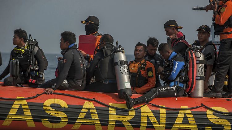Nach dem Flugzeugabsturz fahren an der Suchaktion beteiligte Taucher mit einem Schlauchboot aufs Meer.