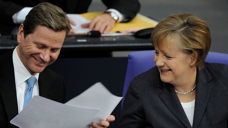 Kanzlerin Merkel zeigt ihrem Außenminister Karikaturen über ihr beiderseitiges Verhältnis. Eine davon war vor ein paar Tagen Titelbild der "taz".