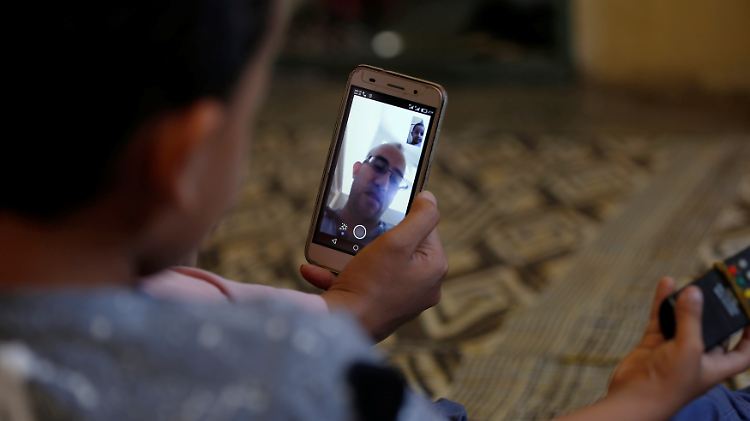 Ein Flüchtling blickt in einer Flüchtlingsunterkunft auf sein Handy. Wenn sich Migranten nicht ausweisen können, sollen ihre Smartphones dem Bamf dabei helfen, mehr über die Identität des Geflüchteten herauszufinden.