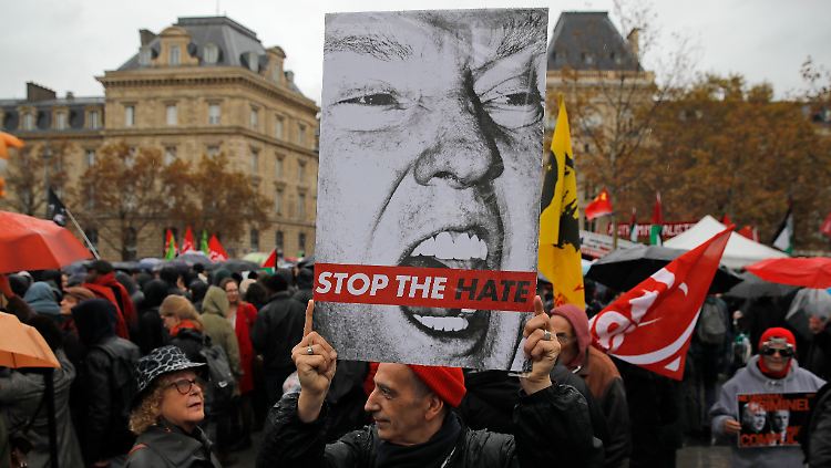 Ein Demonstrant in Paris teilt die Ansicht des französischen Präsidenten und der Bundeskanzlerin.
