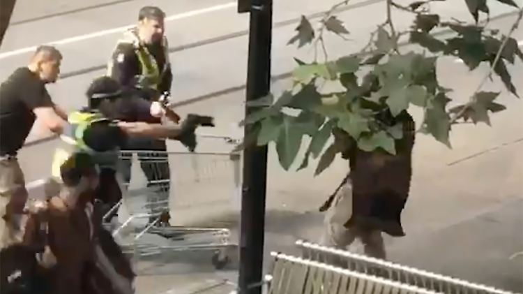 Das Standbild aus einem Video zeigt Michael Rogers (l) mit seinem Einkaufswagen. Rechts ist der Attentäter zu sehen.