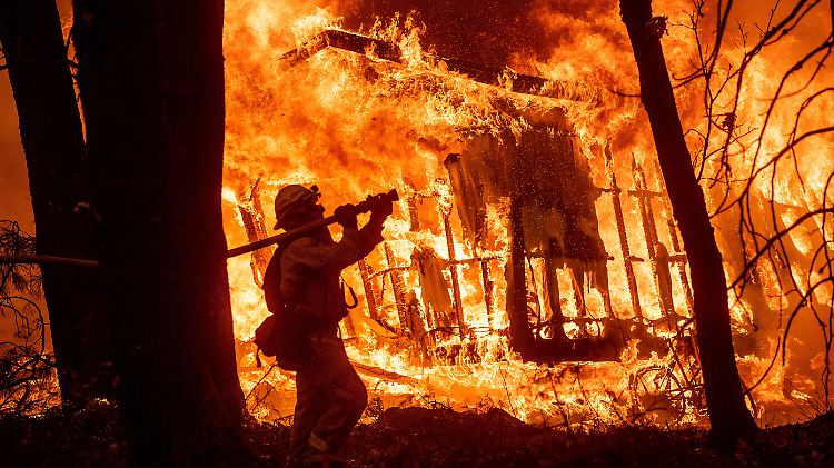 Ein Feuerwehrmann versucht ein brennendes Haus in Kalifornien zu löschen.