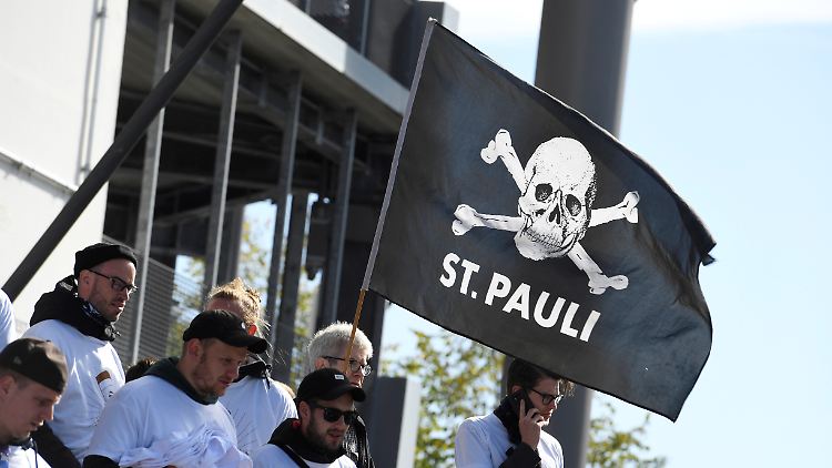 Fans mit der St.-Pauli-Flagge auf der Tribüne.