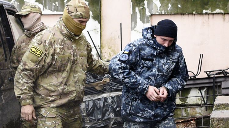 Ein ukrainischer Marinesoldat (rechts) wurde von einem Offizier des russischen Nachrichtendienstes FSB zum Gericht auf der Krim geführt.
