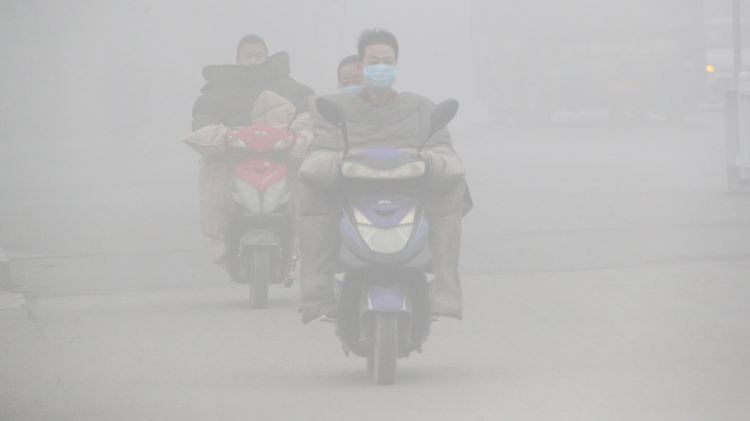 Problem Luftverschmutzung: Mopedfahrer in Huaibei (China) fahren durch dichten Smog.