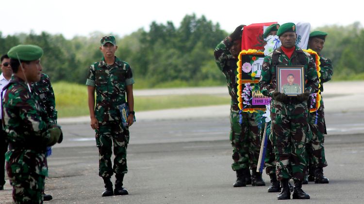 Selbst bei den Bergungsarbeiten soll es zu Angriffen durch Rebellen  gekommen sein: Indonesische Soldaten tragen den Sarg einer ihrer Landsmänner.