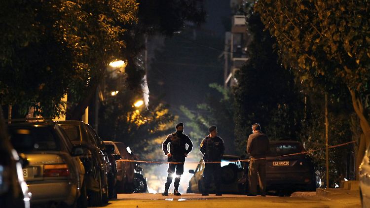 Polizisten sichern im Vorort von Athen die Gegen rund um die Razzia ab.