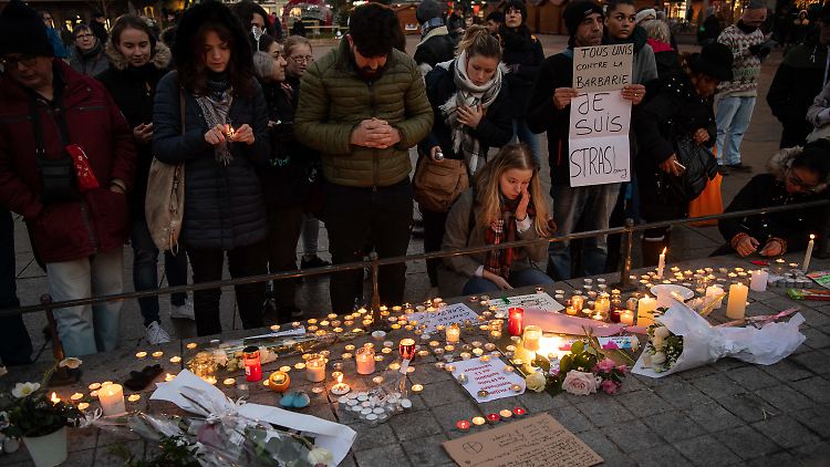 Die Menschen in Straßburg haben etliche Kerzen und Blumen an den Tatort gelegt. Zwei Menschen kamen hier ums Leben, ein weiterer ist hirntot.