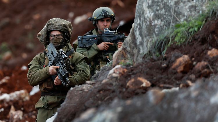 Israelische Soldaten sichern die Arbeiten von Pionieren, die derzeit ein Sperrwerk an der Grenze zum Libanon errichten.