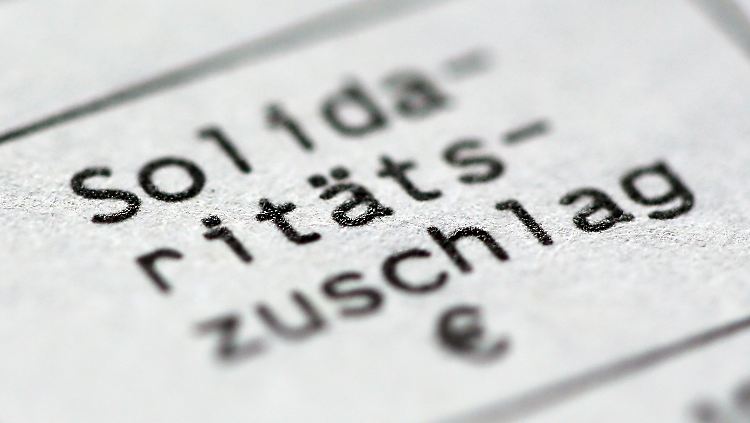 Die Bundesregierung will den Solidaritätszuschlag langsam senken. Doch es gibt auch Forderungen, ihn ganz abzuschaffen.