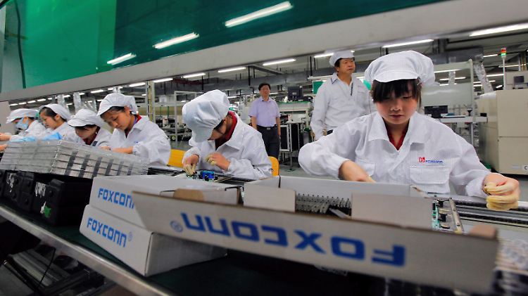 Angestellte einer Foxconn-Fabrik im chinesischen Shenzhen arbeiten an einem Montageband.