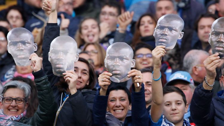 Fans des SSC Neapel halten Masken des rassistisch angefeindeten Profis kalidou Koulibaly.