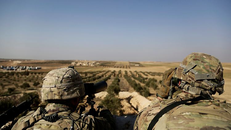 US-Soldaten schauen auf syrischem Gebiet in Richtung türkische Grenze.