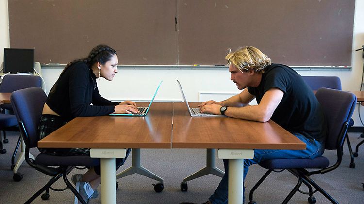 Zwei Studenten der San Francisco State University zeigen, wie Menschen ihren Hals am Computer zusammendrücken.