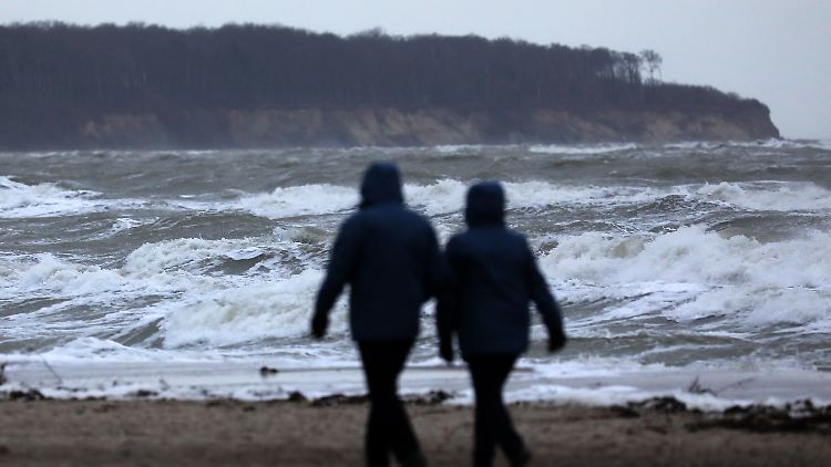 Aufgewühlte Ostsee: Bei Warnemünde trotzen Spaziergänger den Witterungsbedingungen.