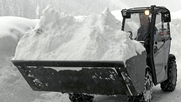 Im österreichischen Niedertauern räumt ein Bagger Schneemassen von der Straße.
