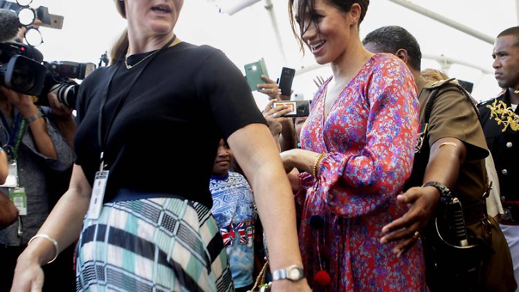 Herzogin Meghan wird von ihrer Personenschützerin über einen überfüllten Markt auf Fiji geschleust.