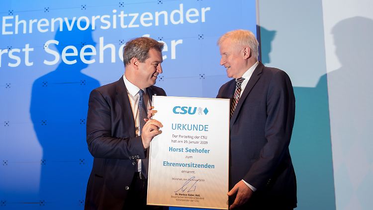 Da lächeln sie beide: Söder überreicht Seehofer die Urkunde, die ihn zum Ehrenvorsitzenden erklärt.