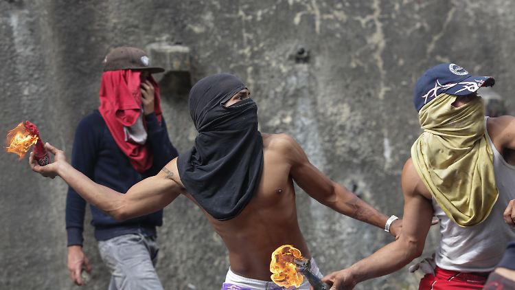 Vermummte Demonstranten werfen Molotow-Cocktails bei Protesten in Caracas.