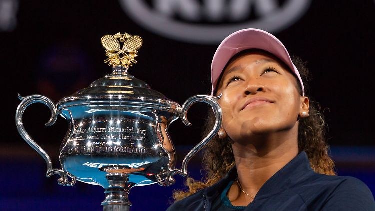 Belohnung für die erfolgreiche Nervenschlacht: Naomi Osaka gewinnt in Melbourne einen Tennis-Krimi gegen Petra Kvitiva und kuschelt verdient mit der Trophäe.