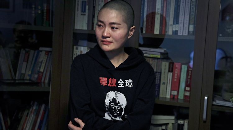 Li Wenzu trägt einen Pullover mit dem Porträt ihres Mannes und der Aufschrift "Befreit Quanzhang".