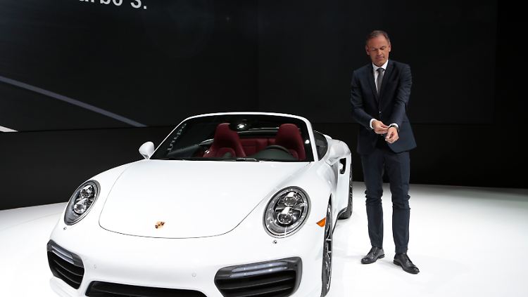 Porsche-Vorstand Dr. Oliver Blume neben einem Sportwagen 911 in Detroit.