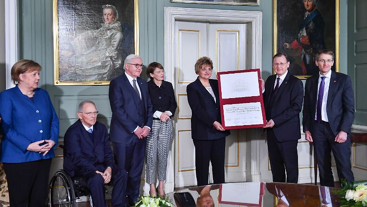Bodo Ramelow, Ministerpräsident von Thüringen, und Birgit Diezel, Landtagspräsidentin in Thüringen, mit dem "Gedenkblatt" zum Festakt 100 Jahre Weimarer Verfassung. Daneben Bundeskanzlerin Angela Merkel, Wolfgang Schäuble , Präsident des Deutschen Bundestages, Bundespräsident Frank-Walter Steinmeier und seine Frau Elke Büdenbender und Bundesratspräsident Daniel Günther (v.l.).