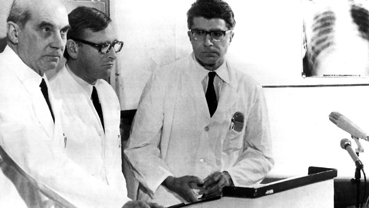 Die Münchner Chirurgen Professor Dr. Rudolf Zenker, Werner Rudolph und Werner Klinner (v.l.) bestätigen am 14. Februar 1969 vor Journalisten, dass am Tag zuvor die erste Herztransplantation in der Bundesrepublik durchgeführt wurde. Der Patient überlebte aber nur etwa einen Tag.