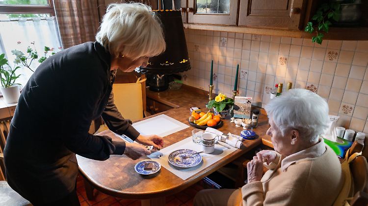 Eine polnische Pflegekraft versorgt eine Seniorin.
