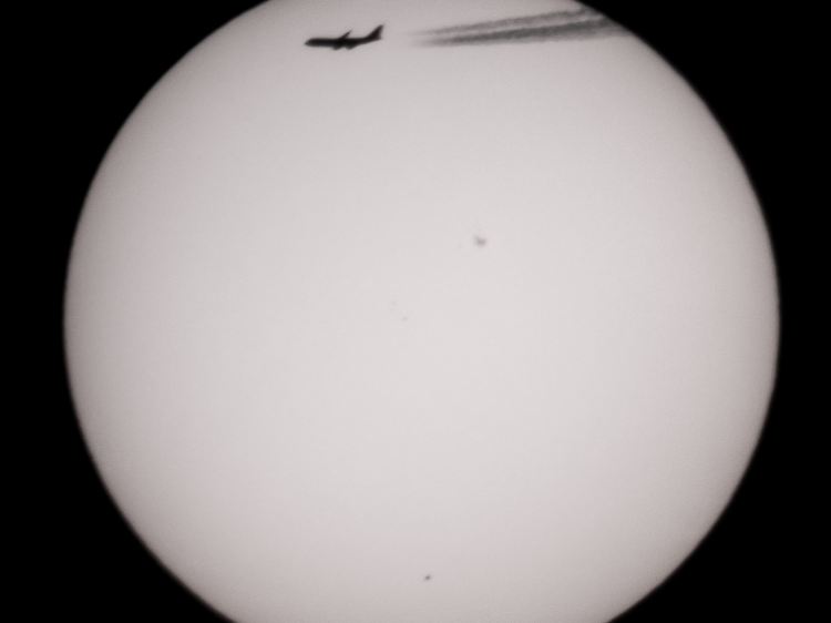Nur als kleiner Punkt ist der Merkur (unten) vor der Sonne zu sehen, zudem einige Sonnenflecken.