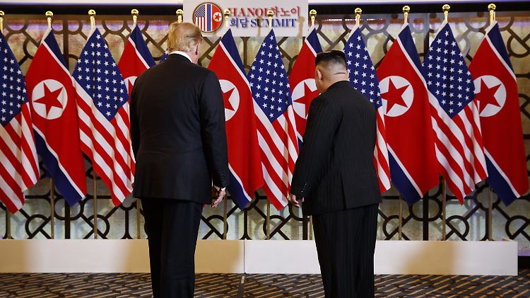 Trump und Kim stehen in Hanoi vor Fahnen ihrer Länder.
