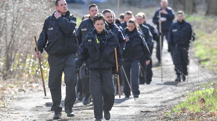 Mit Schaufeln in der Hand machen sich die Polizisten auf den Weg in den Wald bei Storkow (Oder-Spree).