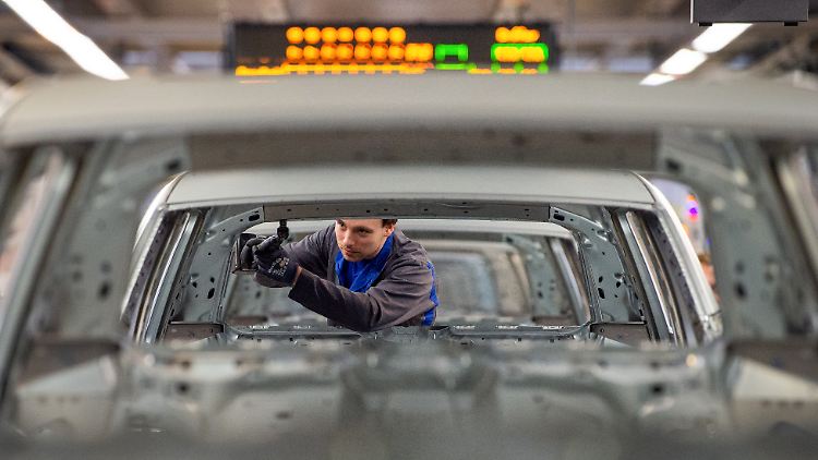 Ein VW-Mitarbeiter in Wolfsburg schraubt an einer Karosserie. Für die Beschäftigen brechen neue Zeiten an.