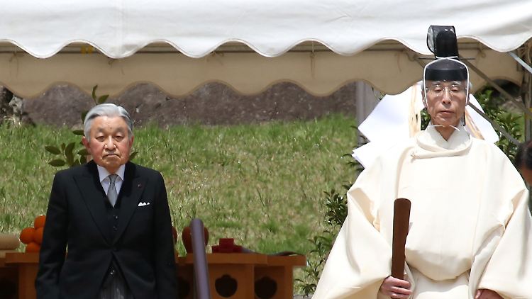 Traditionelle Zeremonie: Kaiser Akihito (l.) wird von einem Shinto-Priester zum Schrein seines Vaters Hirohito begleitet, dem er seine Abdankung verkünden will.