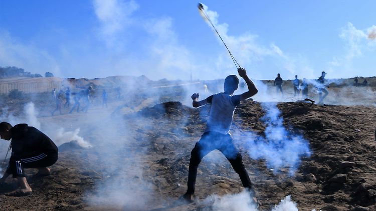 Ein palästinensischer Demonstrant schleudert eine Tränengasgranate auf israelische Sicherheitskräfte.