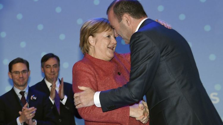 Umarmung nach Webers Wahl zum Spitzenkandidaten für die Europawahl: Merkel gratuliert.