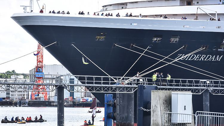 Klimaaktivisten nähern sich dem Schiff mit Booten.