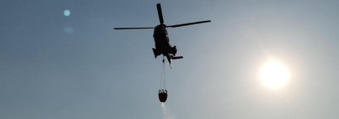 Ein Löschhubschrauber fliegt bei Jüterborg am Himmel. Foto: Julian Stähle/Archivbild