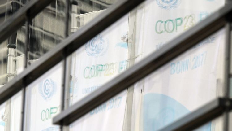 Fahnen der Weltkilimakonferenz 2017 spiegeln sich in Bonn in Fensterscheiben.