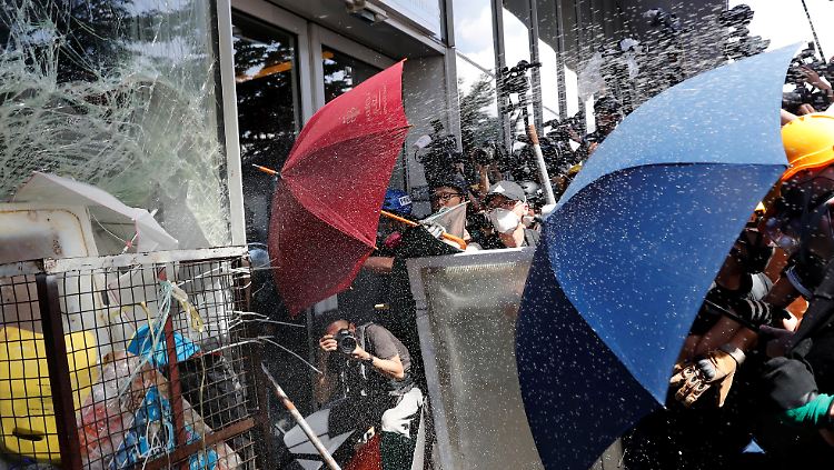 Demonstranten versuchen, ins Parlamentsgebäude zu gelangen, während die Polizei sie mit Pfefferspray daran hindern will.