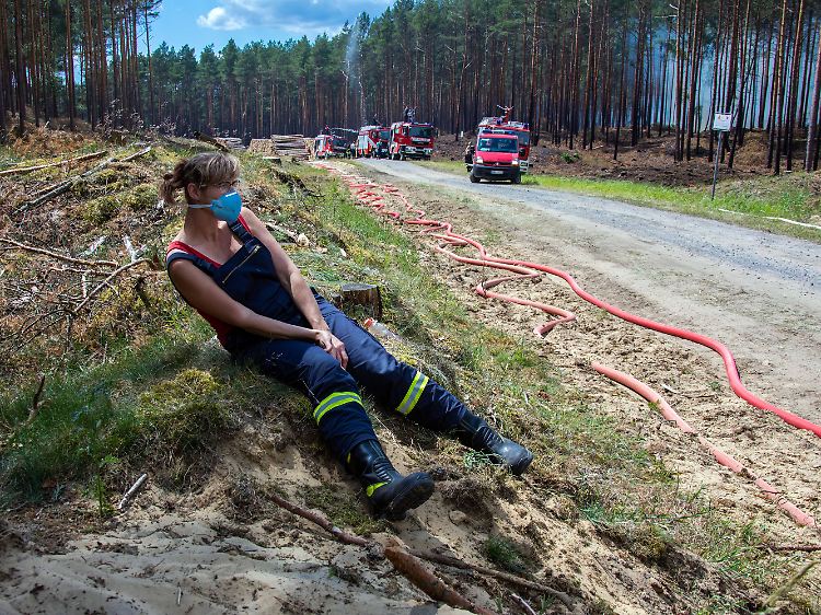Kurze Rast am Rand des brennenden Sperrgebiets: Eine Feuerwehrfrau bei den Sicherungs- und Löscharbeiten bei Lübtheen.
