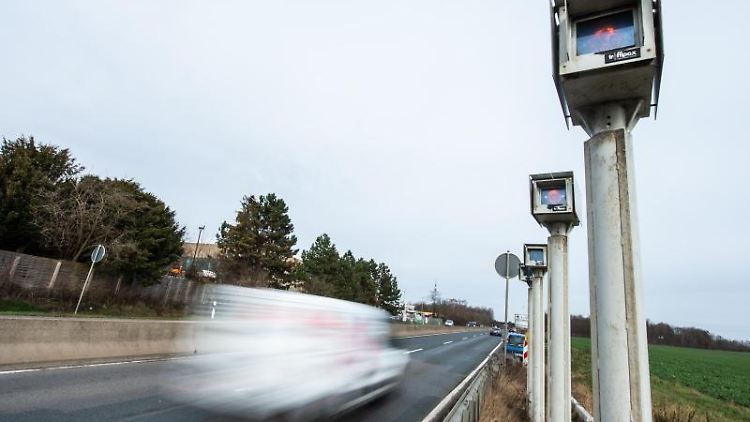 Autos fahren an einem Streckenradar vorbei.  