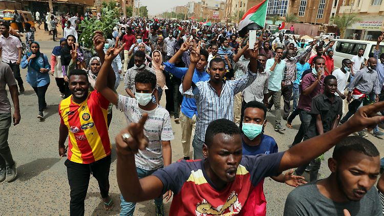 Demonstranten tragen sudanesische Nationalflaggen bei einem Protest gegen die Militärführung im Sudan.