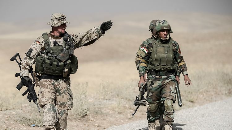Ein Bundeswehr-Soldat weist 2016 kurdische Peshmerga im irakischen Erbil an.
