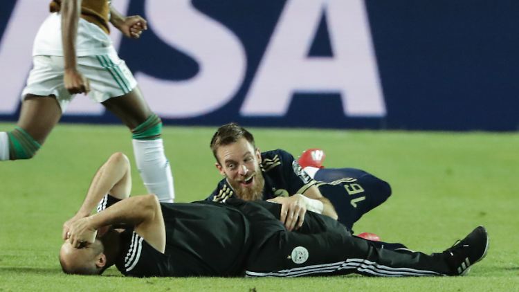Algeriens Nationaltrainer Djamel Belmadi liegt auf dem Boden und feiert den Sieg